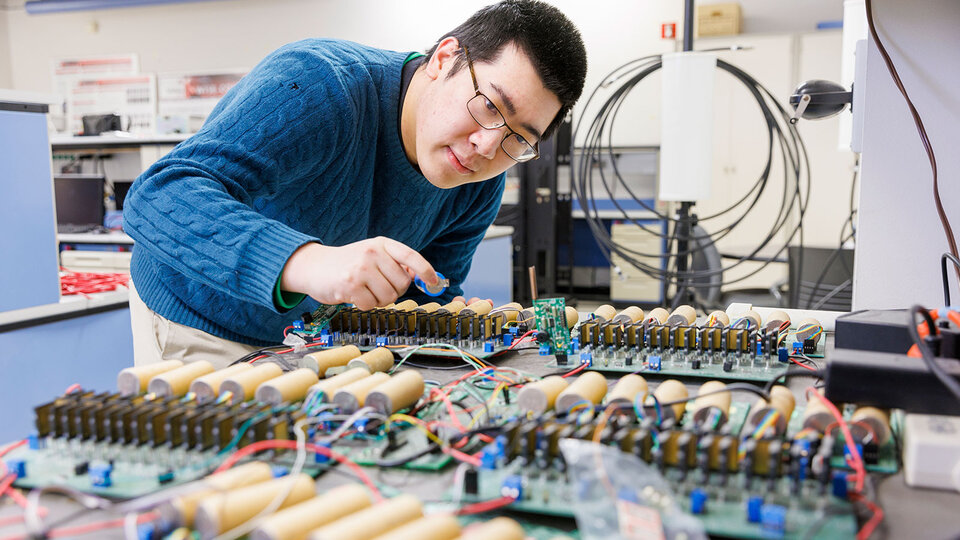 student working on a circut board