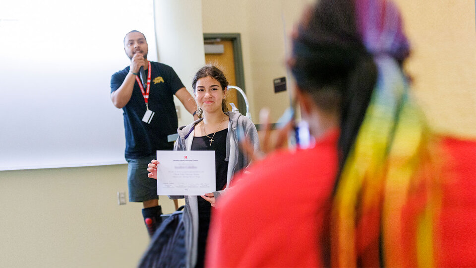 student holding up certificate