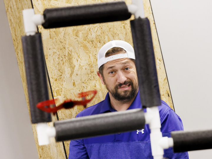 Man driving a drone through small square frame