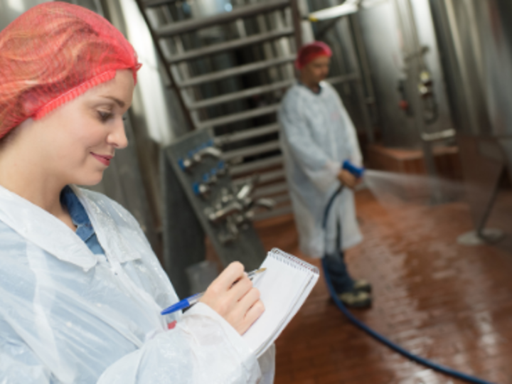 Two food manufacturing workers cleaning work area