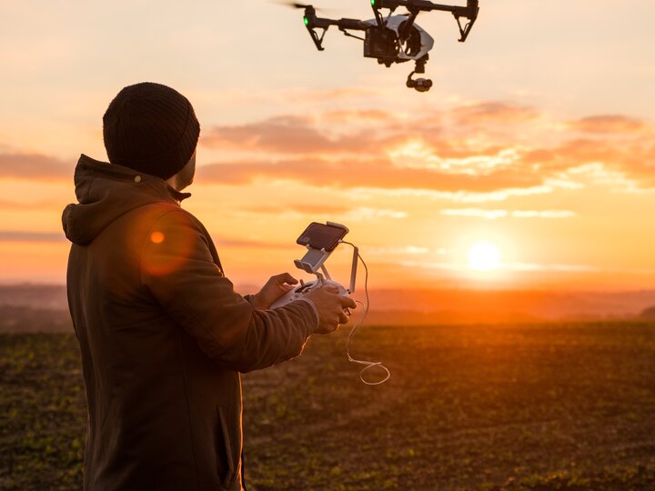 Man flying drone in field